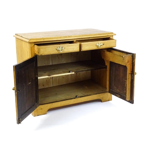 1802 - A late 19thC / early 20thC pine cupboard with a moulded top above two short drawers and two panelled... 