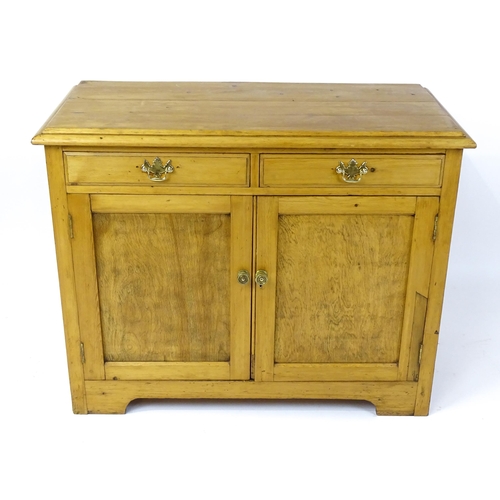 1802 - A late 19thC / early 20thC pine cupboard with a moulded top above two short drawers and two panelled... 