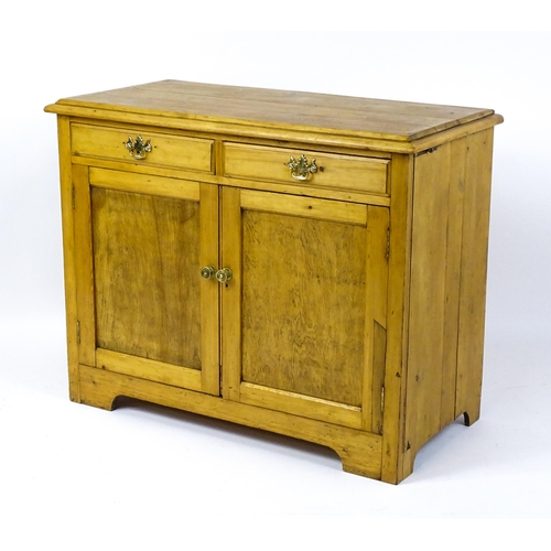 1802 - A late 19thC / early 20thC pine cupboard with a moulded top above two short drawers and two panelled... 