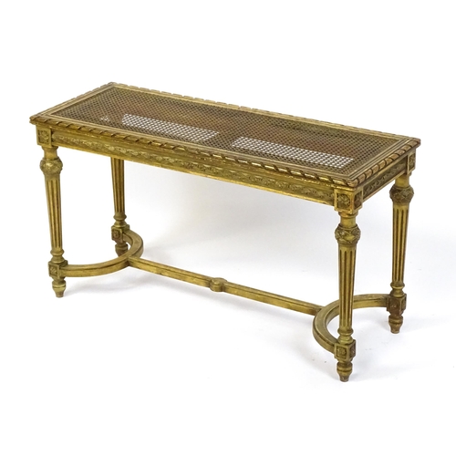 1808 - A 19thC gilt stool with a caned seat raised on four turned tapering legs with fluted decoration and ... 