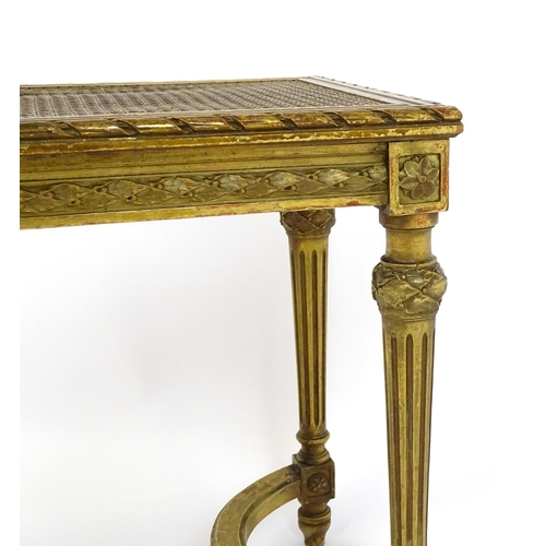 1808 - A 19thC gilt stool with a caned seat raised on four turned tapering legs with fluted decoration and ... 