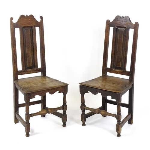 1817 - A pair of 18thC oak side chairs with scrolled cresting rails, panelled backrests and seats raised on... 