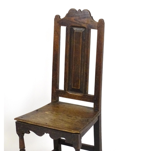 1817 - A pair of 18thC oak side chairs with scrolled cresting rails, panelled backrests and seats raised on... 