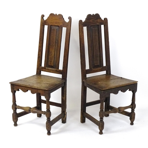 1817 - A pair of 18thC oak side chairs with scrolled cresting rails, panelled backrests and seats raised on... 