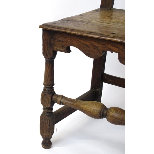 1817 - A pair of 18thC oak side chairs with scrolled cresting rails, panelled backrests and seats raised on... 