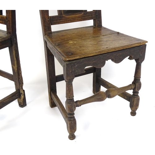 1817 - A pair of 18thC oak side chairs with scrolled cresting rails, panelled backrests and seats raised on... 