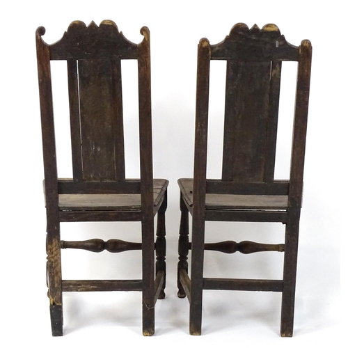 1817 - A pair of 18thC oak side chairs with scrolled cresting rails, panelled backrests and seats raised on... 