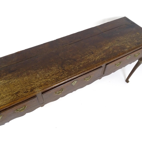 1818 - An 18thC oak dresser base with brass swan neck handles and back plates, the dresser raised on cabrio... 