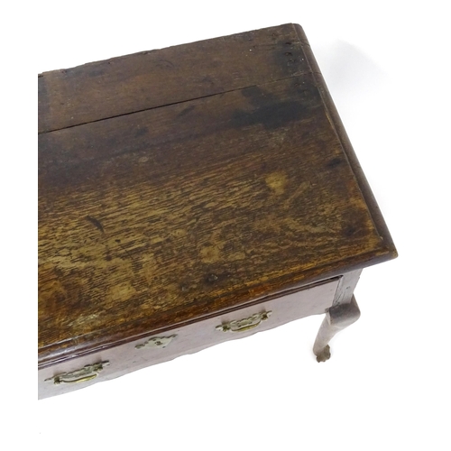 1818 - An 18thC oak dresser base with brass swan neck handles and back plates, the dresser raised on cabrio... 