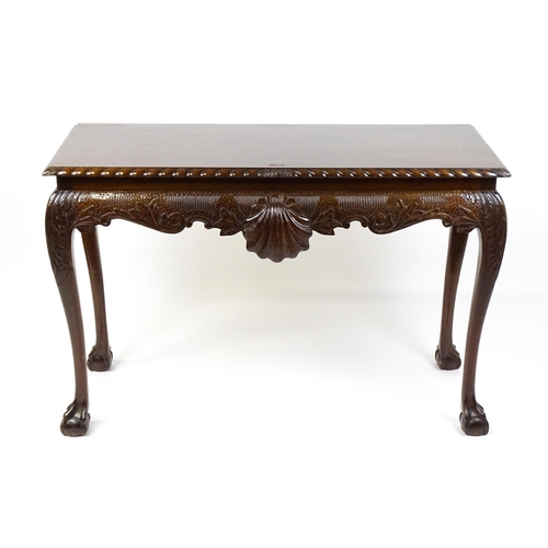 1819 - An antique Irish console table with a gadrooned top edge above a floral and shell carved apron raise... 