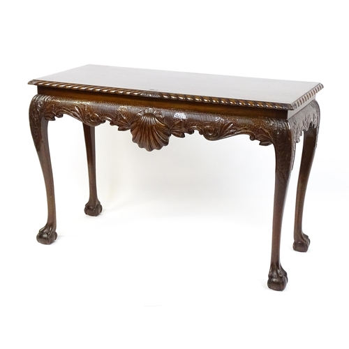 1819 - An antique Irish console table with a gadrooned top edge above a floral and shell carved apron raise... 