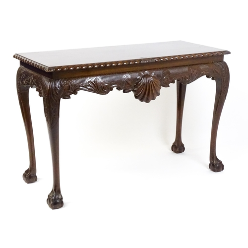 1819 - An antique Irish console table with a gadrooned top edge above a floral and shell carved apron raise... 