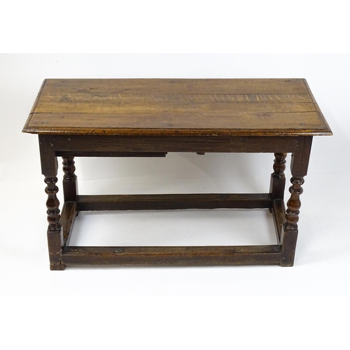 1822 - An 18thC oak side table with a planked top above a single frieze drawer raised on four block and tur... 