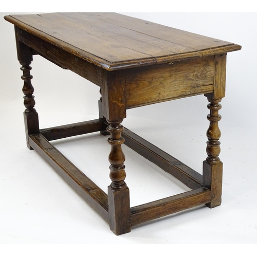 1822 - An 18thC oak side table with a planked top above a single frieze drawer raised on four block and tur... 