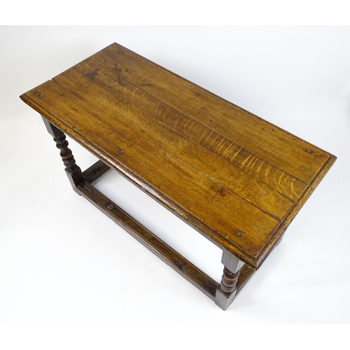 1822 - An 18thC oak side table with a planked top above a single frieze drawer raised on four block and tur... 