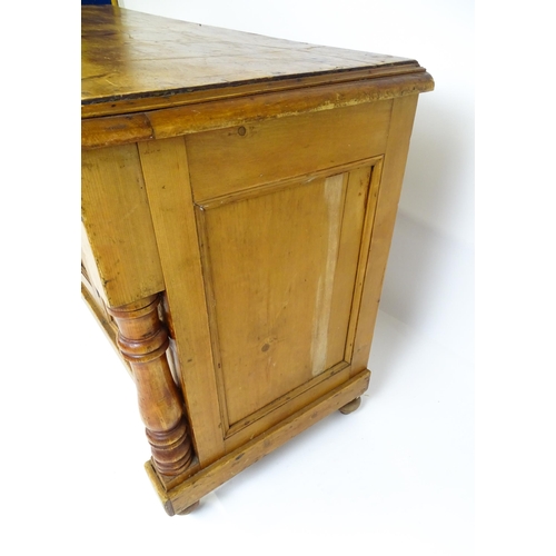 1823 - A Victorian pine dresser with a moulded top above two frieze drawers and a panelled cupboard flanked... 