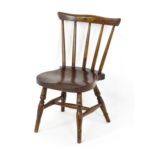 1825 - A late 19thC / early 20thC child's Windsor chair with a comb back, shaped seat and raised on four tu... 