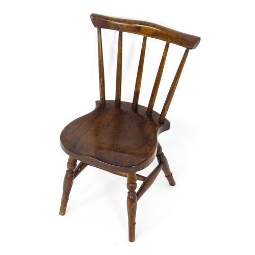 1825 - A late 19thC / early 20thC child's Windsor chair with a comb back, shaped seat and raised on four tu... 