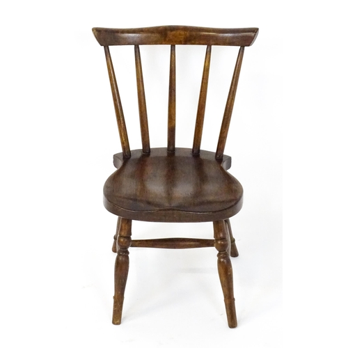 1825 - A late 19thC / early 20thC child's Windsor chair with a comb back, shaped seat and raised on four tu... 