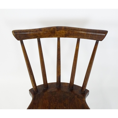 1825 - A late 19thC / early 20thC child's Windsor chair with a comb back, shaped seat and raised on four tu... 