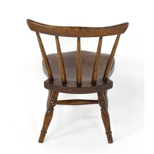 1825 - A late 19thC / early 20thC child's Windsor chair with a comb back, shaped seat and raised on four tu... 