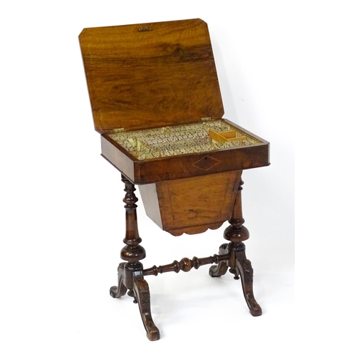 1827 - A Victorian walnut sewing table with satinwood decorative inlay, the lid opening to show fitted comp... 