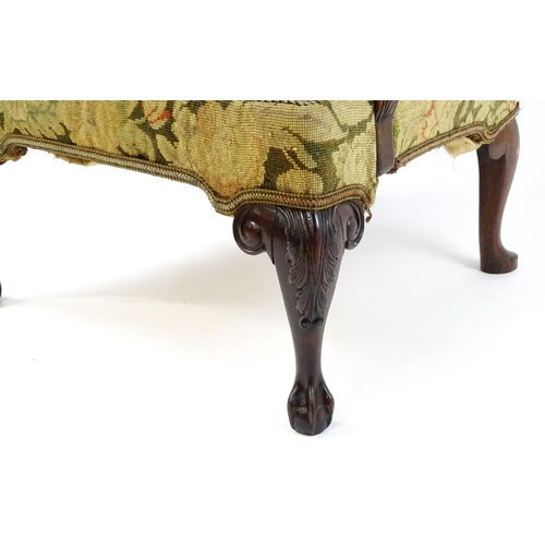 1834 - An 18thC Irish Gainsborough chair with needlework tapestry upholstery and acanthus carved arms raise... 