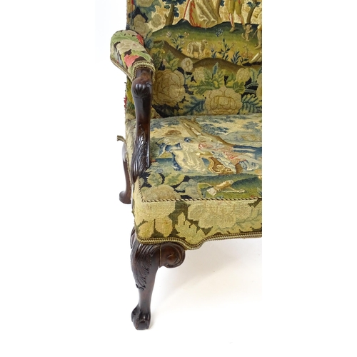 1834 - An 18thC Irish Gainsborough chair with needlework tapestry upholstery and acanthus carved arms raise... 