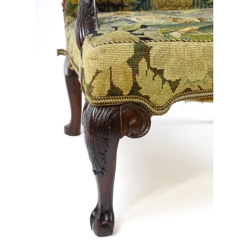 1834 - An 18thC Irish Gainsborough chair with needlework tapestry upholstery and acanthus carved arms raise... 