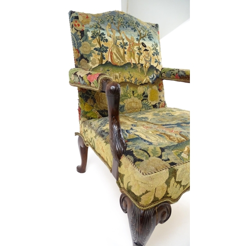 1834 - An 18thC Irish Gainsborough chair with needlework tapestry upholstery and acanthus carved arms raise... 