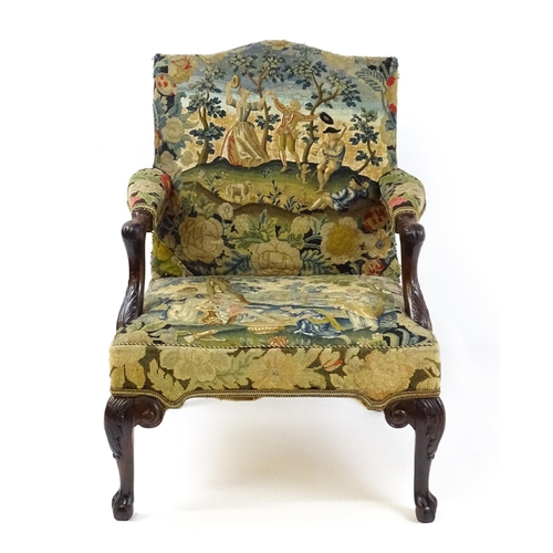 1834 - An 18thC Irish Gainsborough chair with needlework tapestry upholstery and acanthus carved arms raise... 