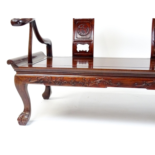 1842 - An early 20thC Chinese elm bench with scrolled arms,, carved pierced back rests  and raised on four ... 