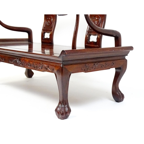 1842 - An early 20thC Chinese elm bench with scrolled arms,, carved pierced back rests  and raised on four ... 