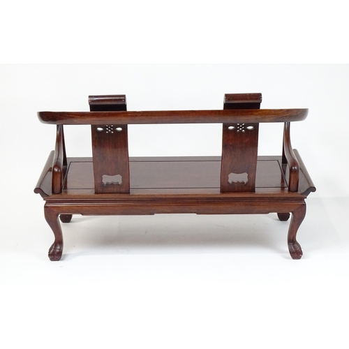 1842 - An early 20thC Chinese elm bench with scrolled arms,, carved pierced back rests  and raised on four ... 