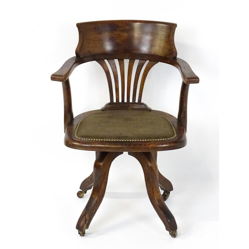 1843 - A late 19thC / early 20thC revolving captains chair with a fanned back splat, upholstered seat and b... 