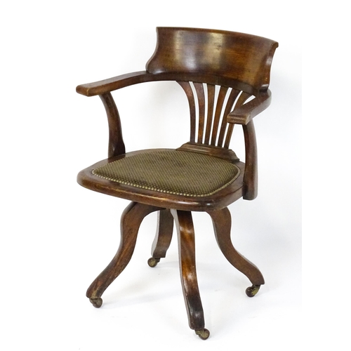 1843 - A late 19thC / early 20thC revolving captains chair with a fanned back splat, upholstered seat and b... 