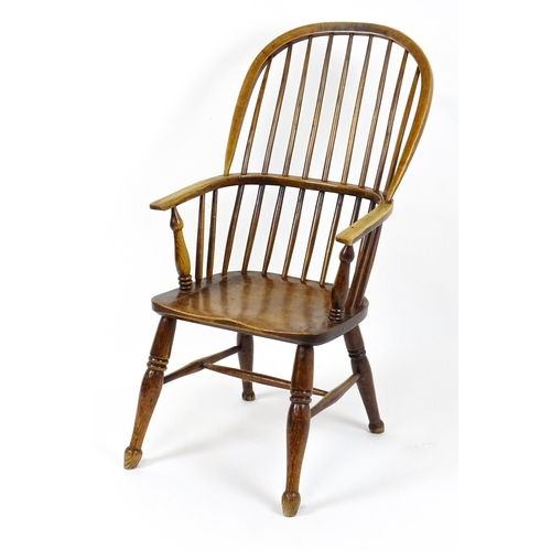 1844 - A 19thC double bow back Windsor chair with a shaped seat and raised on turned tapering legs united b... 