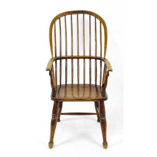 1844 - A 19thC double bow back Windsor chair with a shaped seat and raised on turned tapering legs united b... 