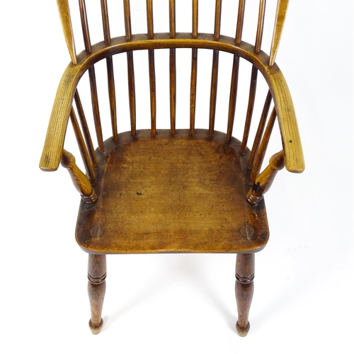 1844 - A 19thC double bow back Windsor chair with a shaped seat and raised on turned tapering legs united b... 