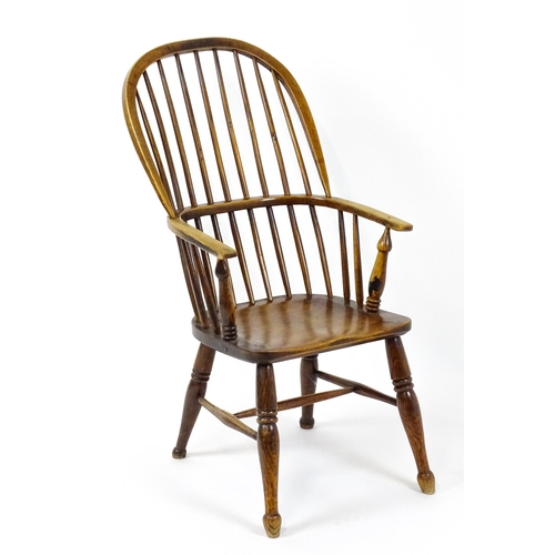 1844 - A 19thC double bow back Windsor chair with a shaped seat and raised on turned tapering legs united b... 