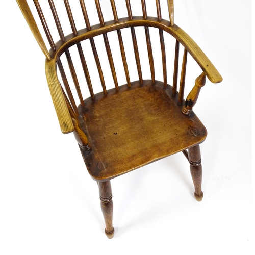 1844 - A 19thC double bow back Windsor chair with a shaped seat and raised on turned tapering legs united b... 