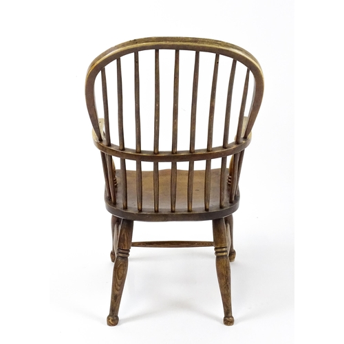 1844 - A 19thC double bow back Windsor chair with a shaped seat and raised on turned tapering legs united b... 