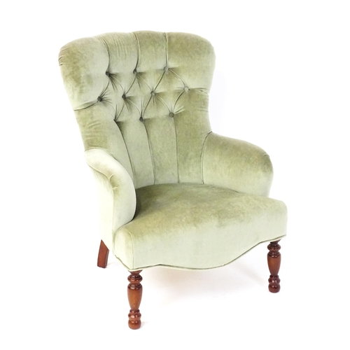 1852 - A late 20thC button back armchair raised on turned tapering front legs. 24