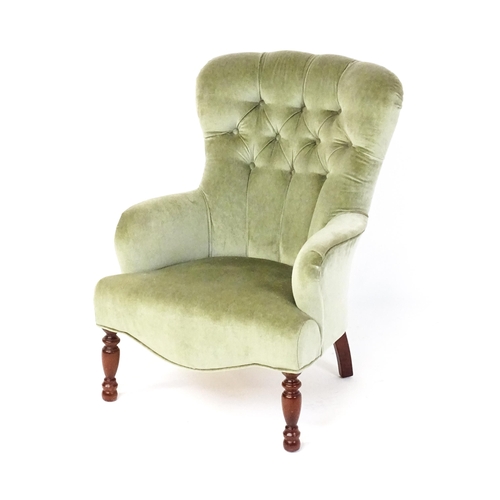 1852 - A late 20thC button back armchair raised on turned tapering front legs. 24