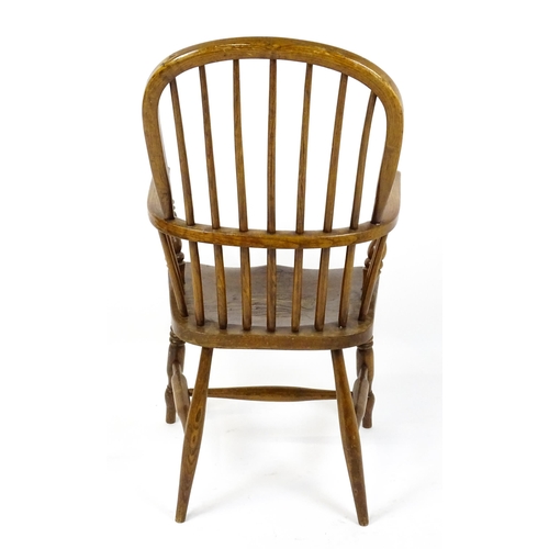 1857 - A mid 19thC double bow back Windsor chair with a shaped seat raised on four turned tapering legs uni... 