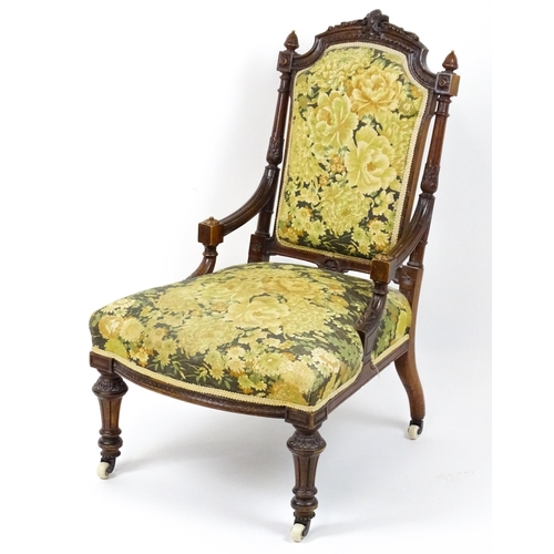 1859 - A 19thC walnut nursing chair surmounted by turned finials and having fluted supports with acanthus c... 