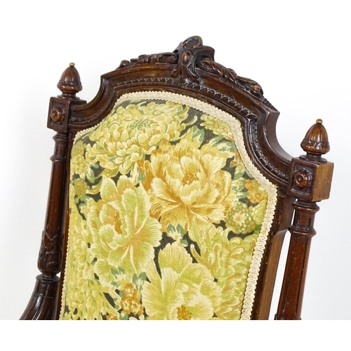 1859 - A 19thC walnut nursing chair surmounted by turned finials and having fluted supports with acanthus c... 