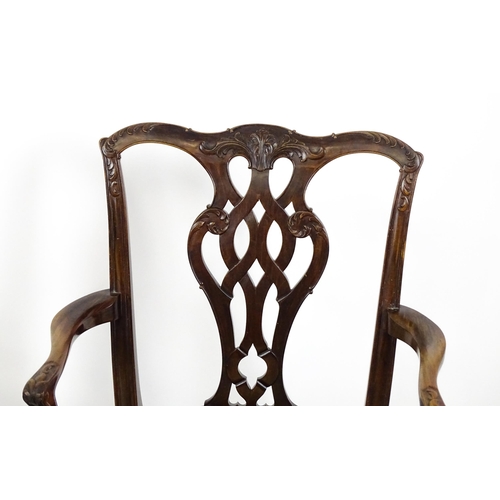 1861 - A pair of late 19thC Chippendale style open armchairs, with pierced and carved back splats above spl... 