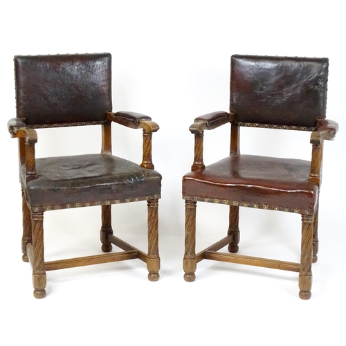 1863 - A pair of late 19thC / early 20thC leather upholstered armchairs with swept arms and brass detailing... 