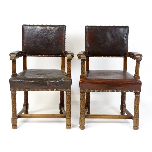 1863 - A pair of late 19thC / early 20thC leather upholstered armchairs with swept arms and brass detailing... 